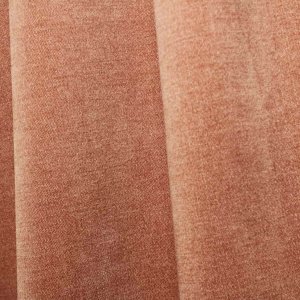 Sfeerfoto van zachtroze chenille gordijnen van Okika, getoond in de plooi, met een zachte en rustige uitstraling bij natuurlijk licht in het interieur.