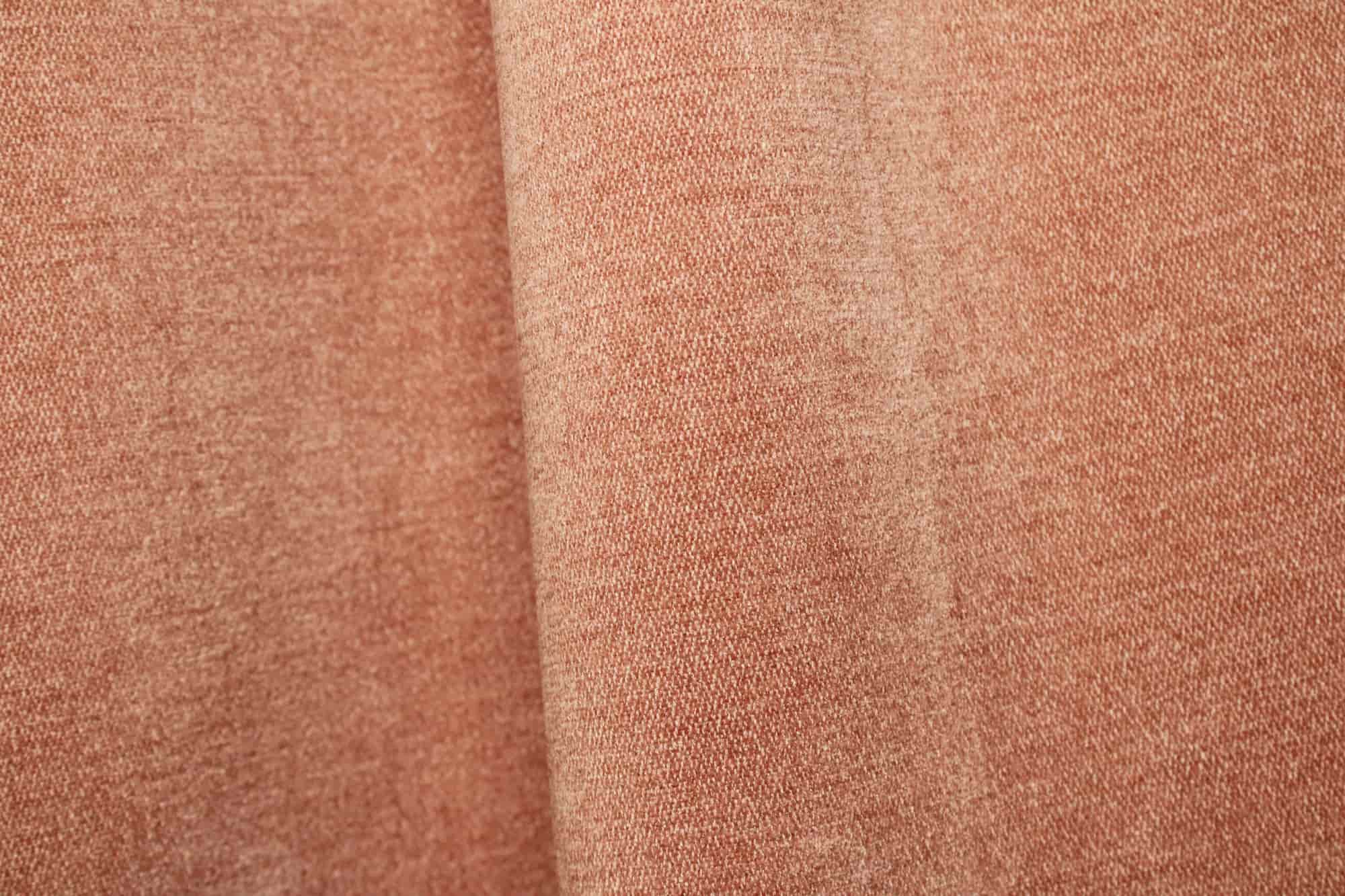 Stofdetails van zachtroze chenille gordijnen van Okika, met een zachte structuur en subtiele kleurnuance zichtbaar bij natuurlijk licht