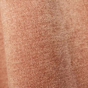 Stofpatroon van zachtroze chenille gordijnen van Okika, met zicht op de volle stof in de plooi en de zachte, gelijkmatige structuur.