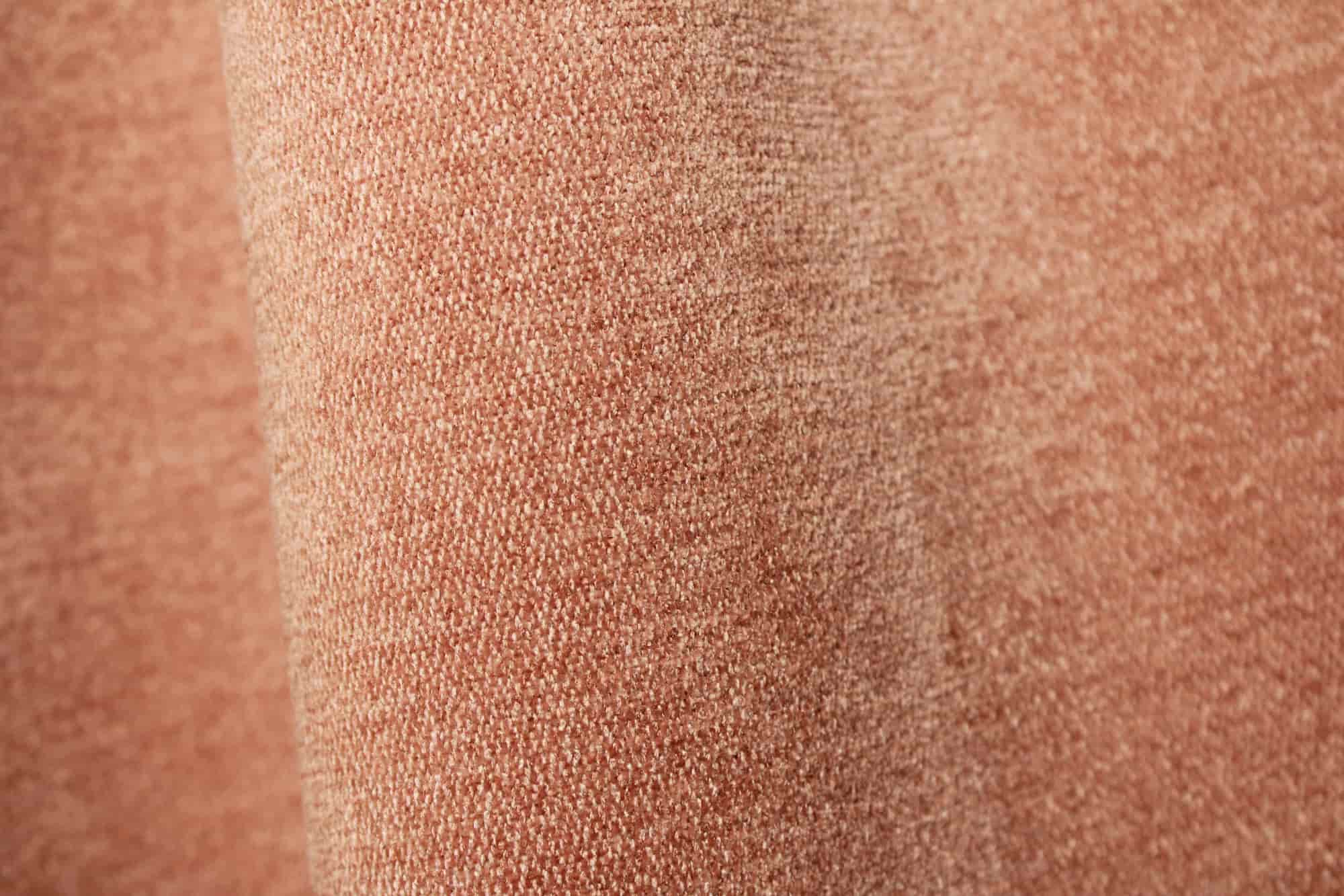 Stofpatroon van zachtroze chenille gordijnen van Okika, met zicht op de volle stof in de plooi en de zachte, gelijkmatige structuur.