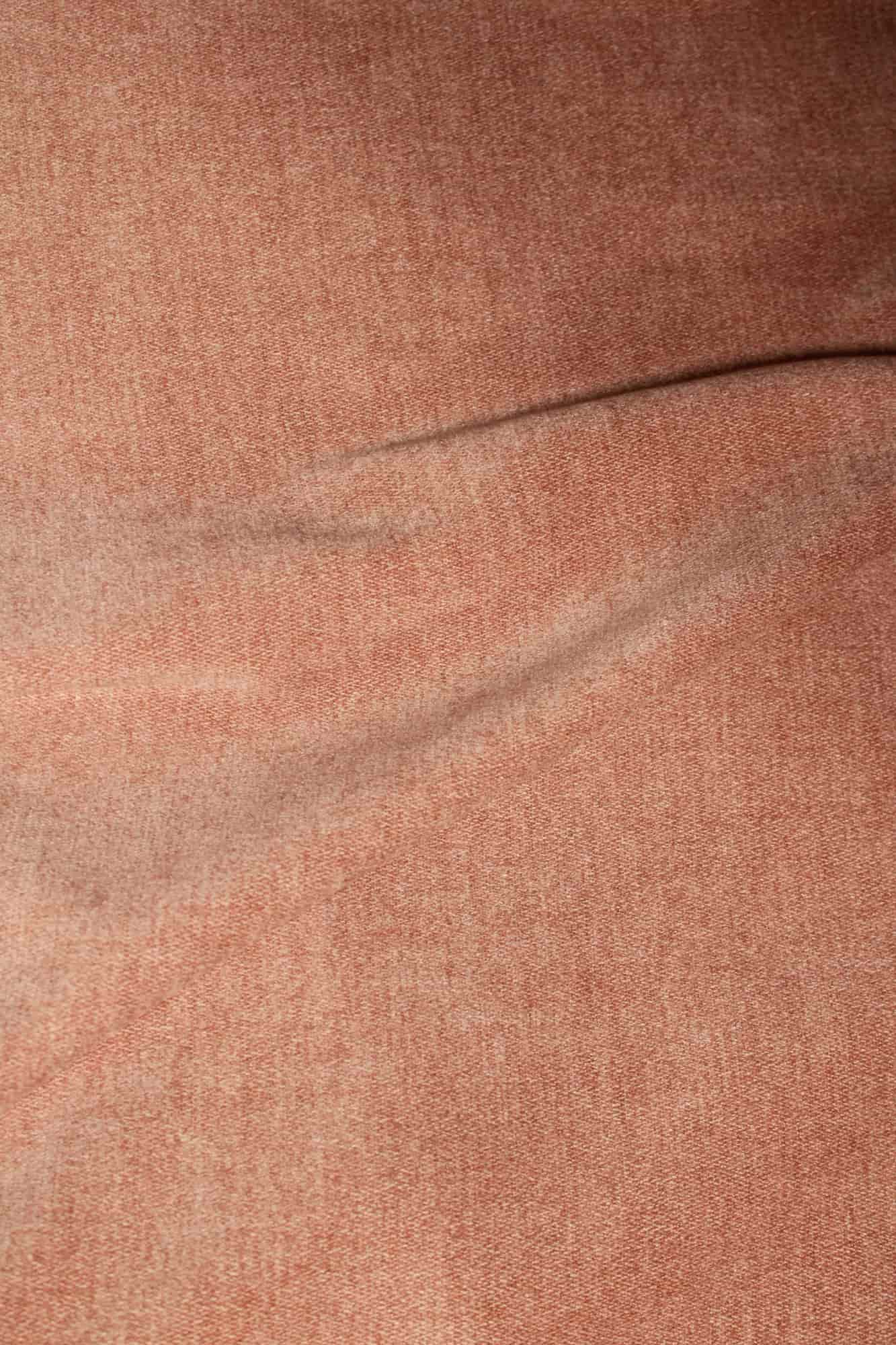 Stofstructuur van zachtroze chenille gordijnen van Okika, van dichtbij gefotografeerd met duidelijk zicht op de zachte weving bij daglicht.