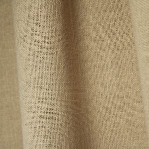Stofdetails van beige gordijnen uit de Boucloir collectie JC2604, close-up van de semilichtdoorlatende stof waarbij de structuur en details van de stof zichtbaar zijn in de plooien.