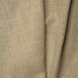 stofstructuur van beige gordijnen uit de Boucloir collectie JC2604, close-up van de semilichtdoorlatende weving met duidelijk zichtbare structuur in daglicht.