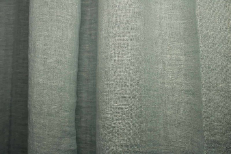 Blauwe inbetween linnen gordijnen uit de Opale collectie JC1998 Dit is een sfeerfoto met gordijnen in plooien.