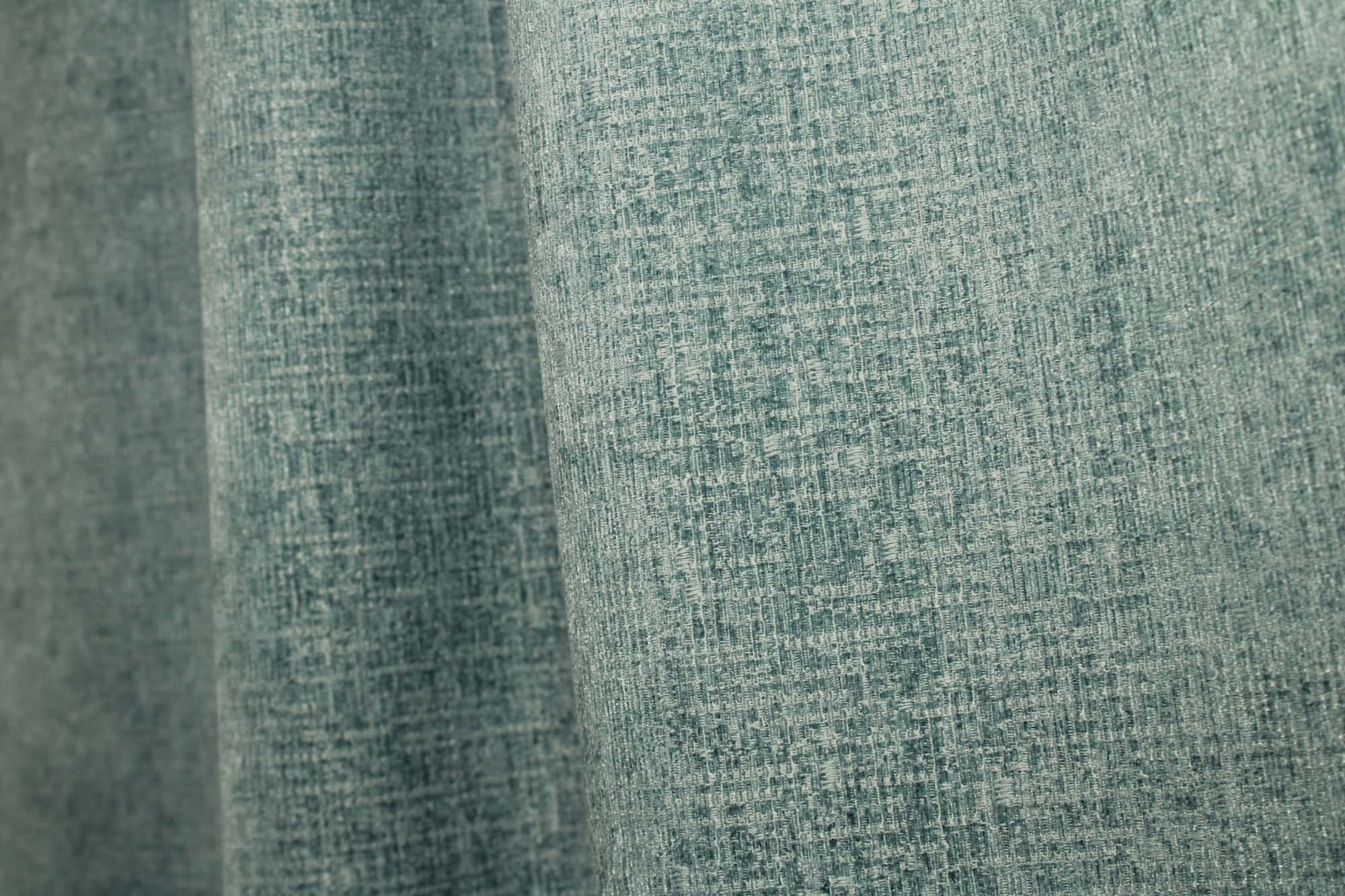 Stofdetails van blauwe teddy chenille gordijnen van Okika, met een en een gelijkmatige weving bij daglicht.