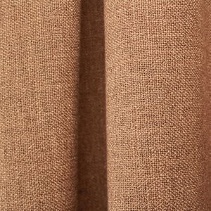 bruine gordijnen uit de Boucloir collectie JC2598 in een warm interieur, semilichtdoorlatende stof met natuurlijke lichtinval. Dit is een sfeerbeeld waarbij de gordijnen in plooien zijn weergegeven.