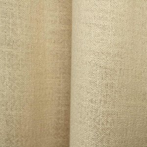 Crèmekleurige gordijnen uit de Boucloir collectie JC2603 in een licht interieur, semilichtdoorlatende stof met zachte lichtinval. Dit is een sfeerbeeld waarbij de gordijnen in plooien zijn gefotografeerd