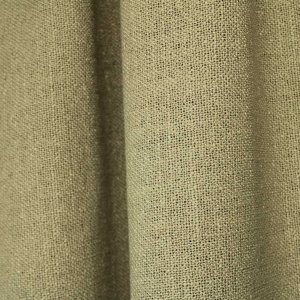 pistachekleurige gordijnen uit de Boucloir collectie JC2609, waarin de zachte groentint rustig oogt en het licht subtiel door de stof wordt gefilterd. Dit is een sfeerfoto met gordijnen in plooien.