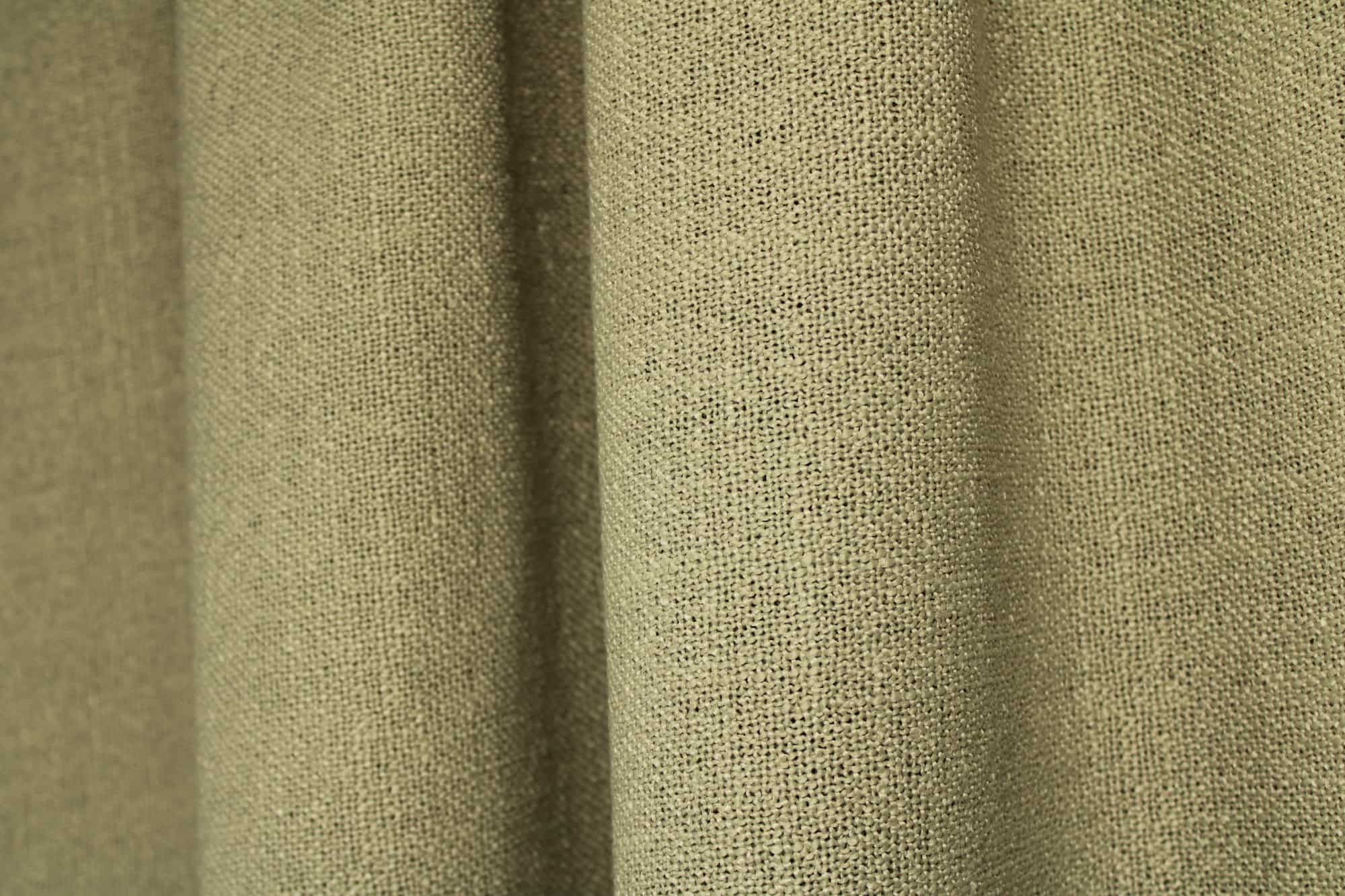 pistachekleurige gordijnen uit de Boucloir collectie JC2609, waarin de zachte groentint rustig oogt en het licht subtiel door de stof wordt gefilterd. Dit is een sfeerfoto met gordijnen in plooien.