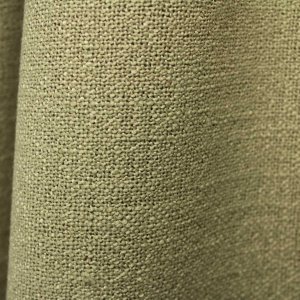 Close up van pistachekleurige gordijnstof uit de Boucloir collectie JC2609, waarbij de overtwist garen en lichte transparantie van de stof goed zichtbaar zijn.