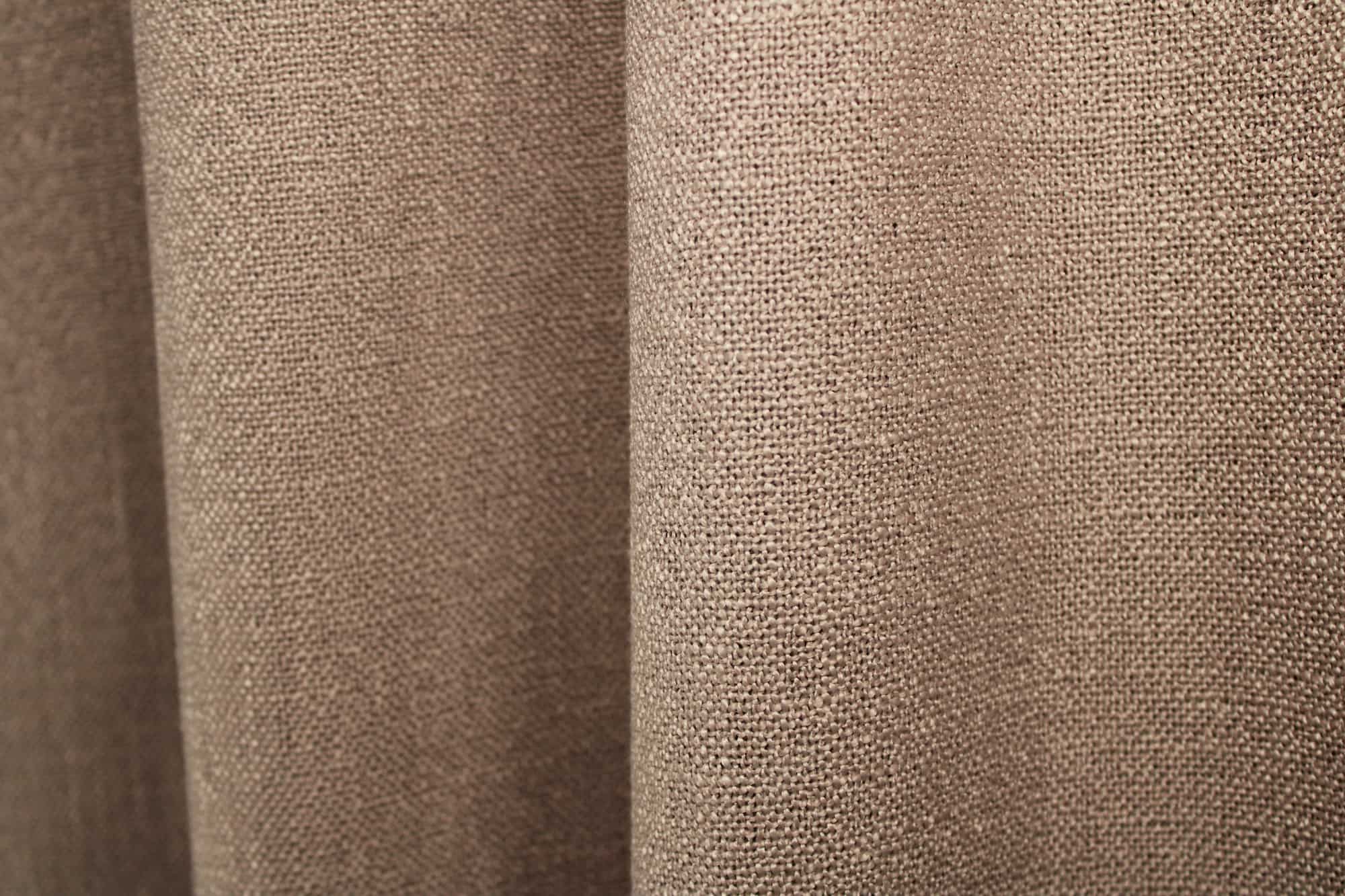 Dit is een sfeerfoto met gordijnen in plooien, waarin soft taupe gordijnen uit de Boucloir collectie JC2601 zijn te zien.