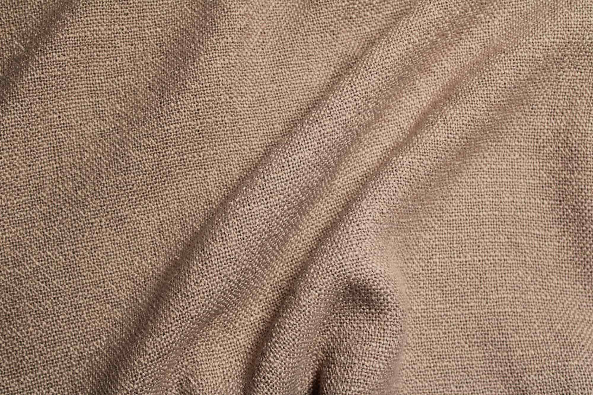 de stofstructuur met overtwist garen van de boucloir gordijnen in het soft taupe van okika