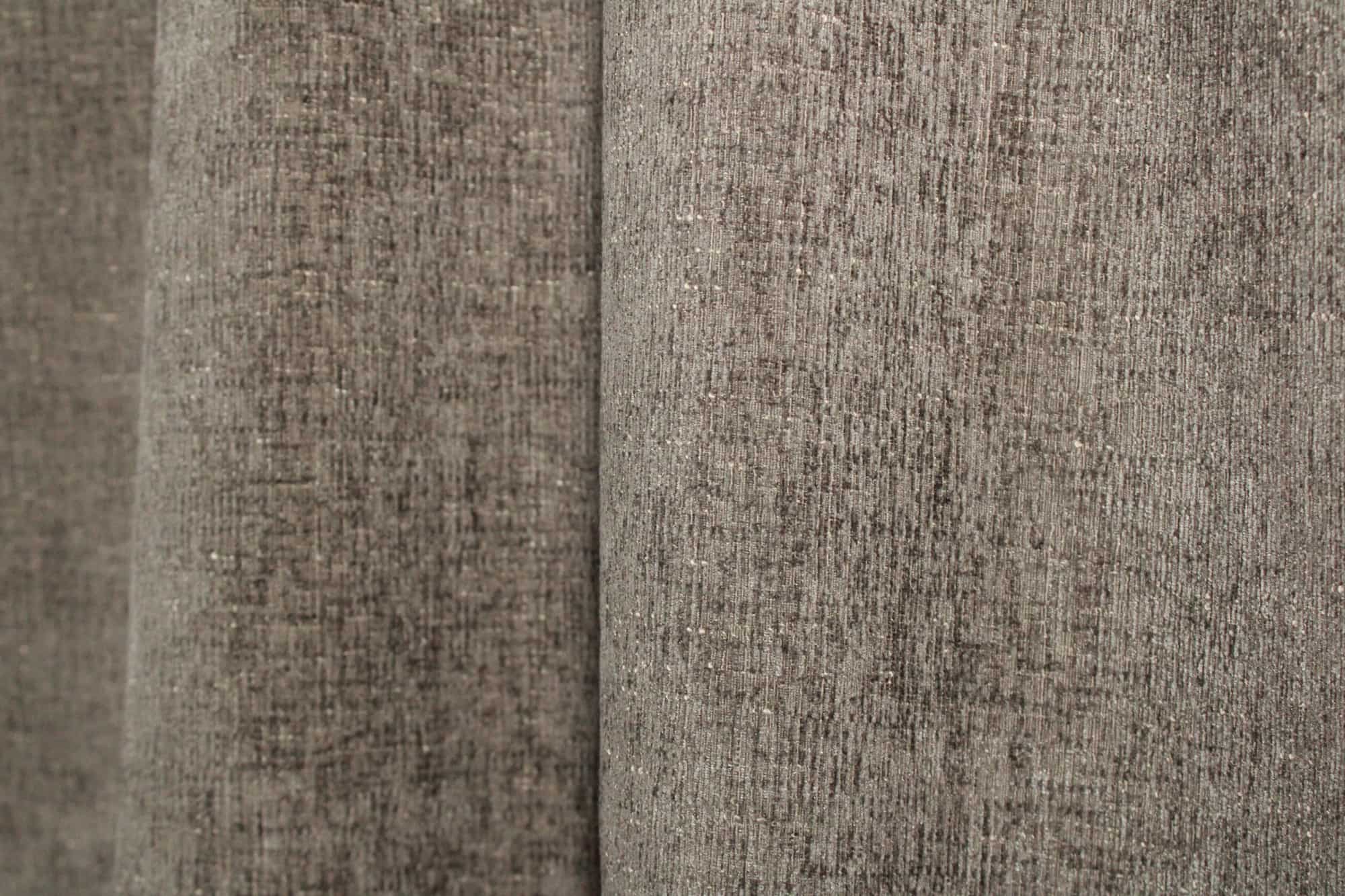 Stofdetails van taupekleurige teddy chenille gordijnen van Okika, met een teddy zachte structuur en een chenille weving bij daglicht.