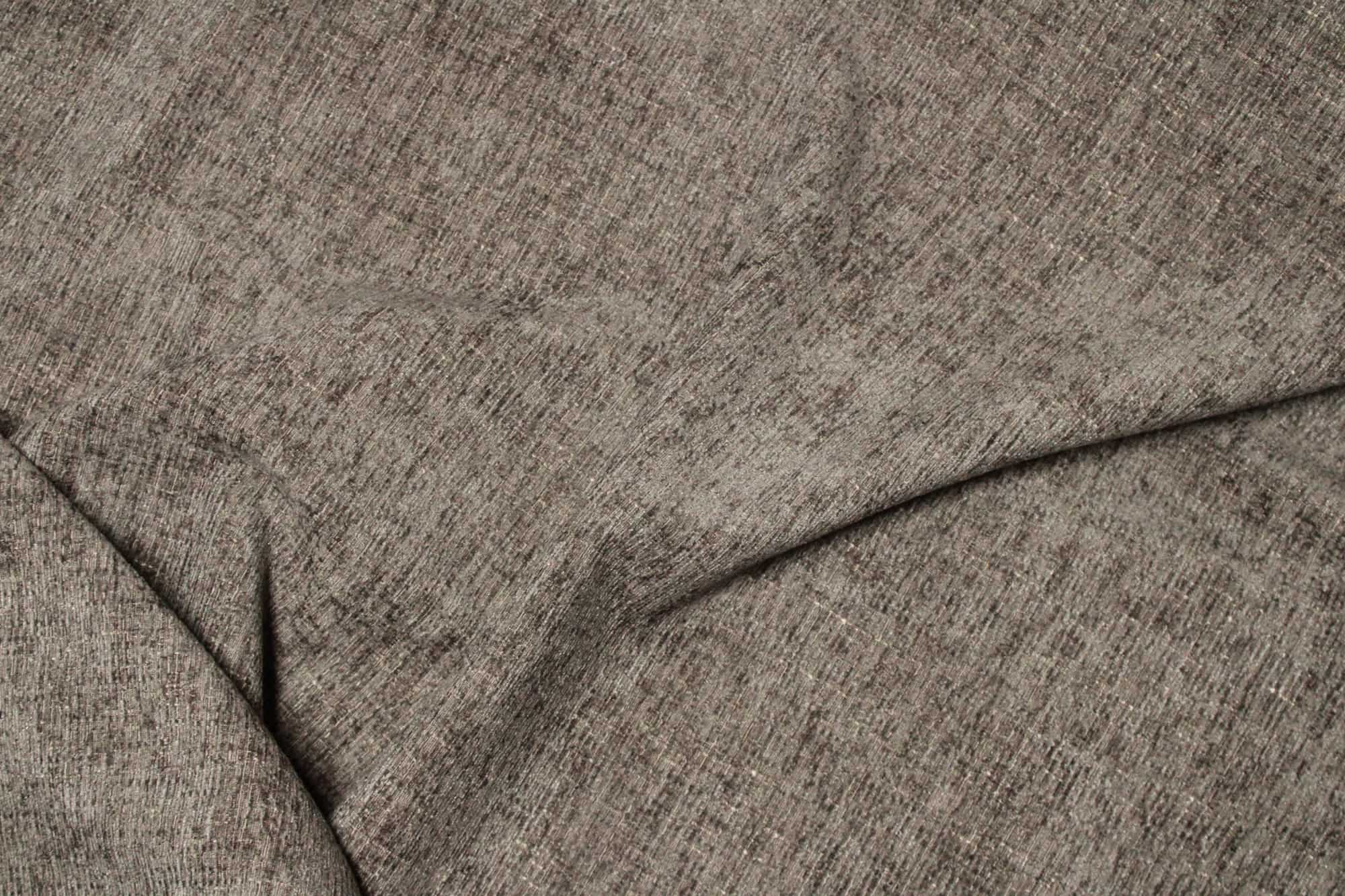 Stofstructuur van taupekleurige teddy chenille gordijnen van Okika, van dichtbij gefotografeerd met zichtbaar zachtestof en een gelijkmatige structuur bij daglicht.