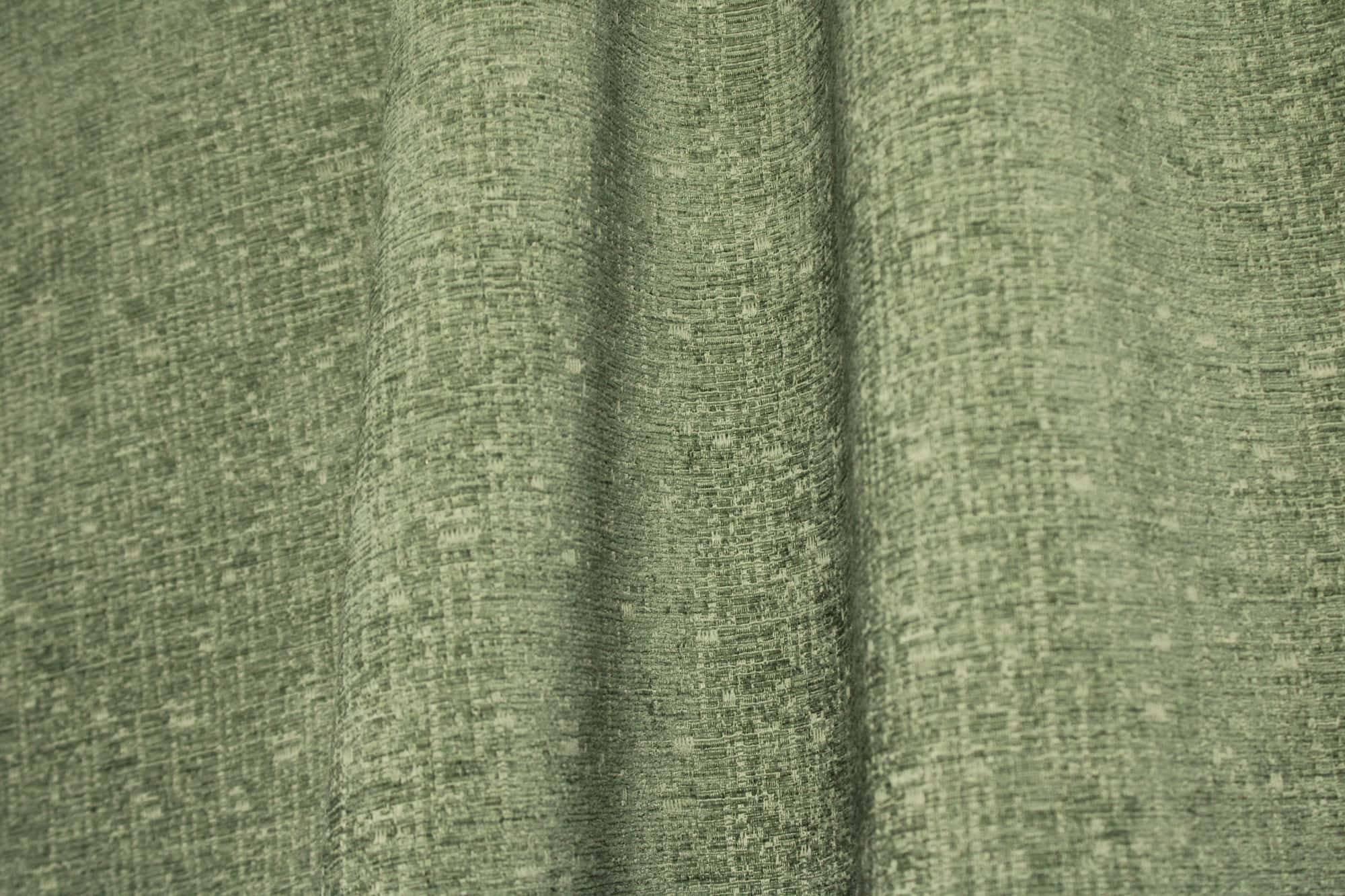 Sfeerfoto van zachtgroene teddy chenille gordijnen van Okika, getoond in de plooi, met een rustige uitstraling bij natuurlijk lichtt