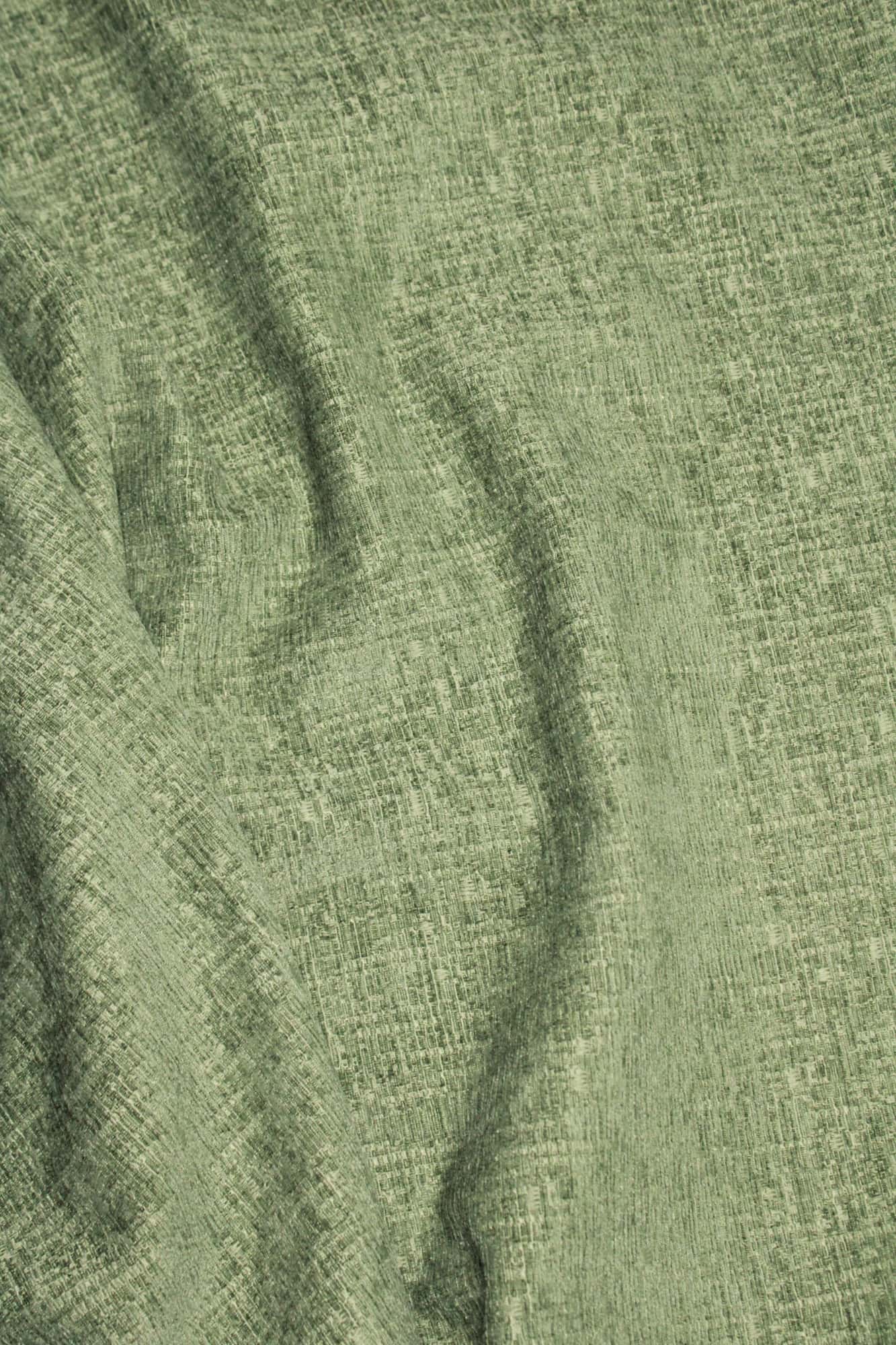 Stofstructuur van zachtgroene teddy chenille gordijnen van Okika, van dichtbij gefotografeerd met de stof in elkaar gedraaid