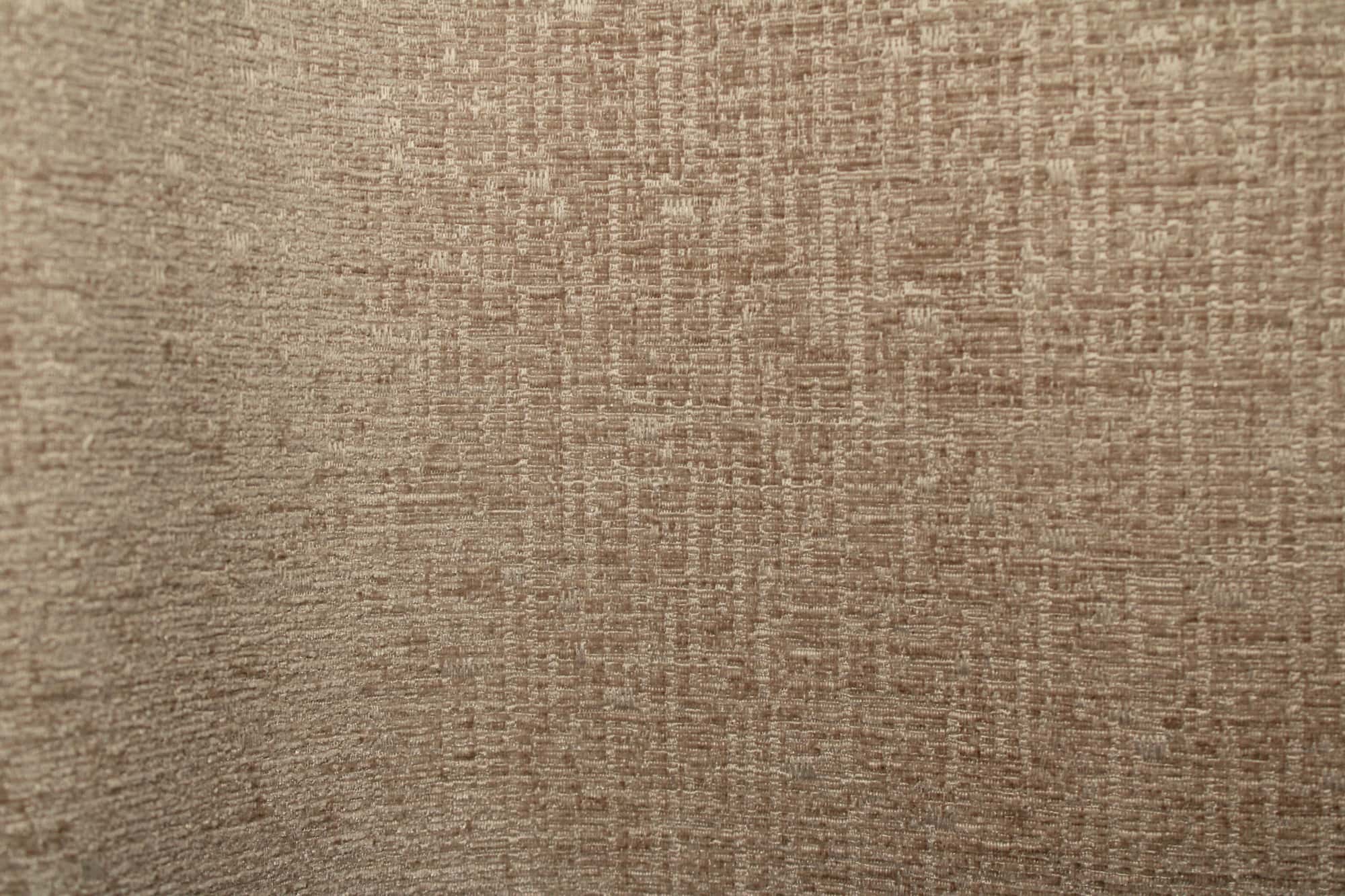 Stofpatroon van zandkleurige teddy chenille gordijnen van Okika, waarbij de plooi de volle chenillie achtige stof en de gelijkmatige, zachte teddystructuur laat zien.