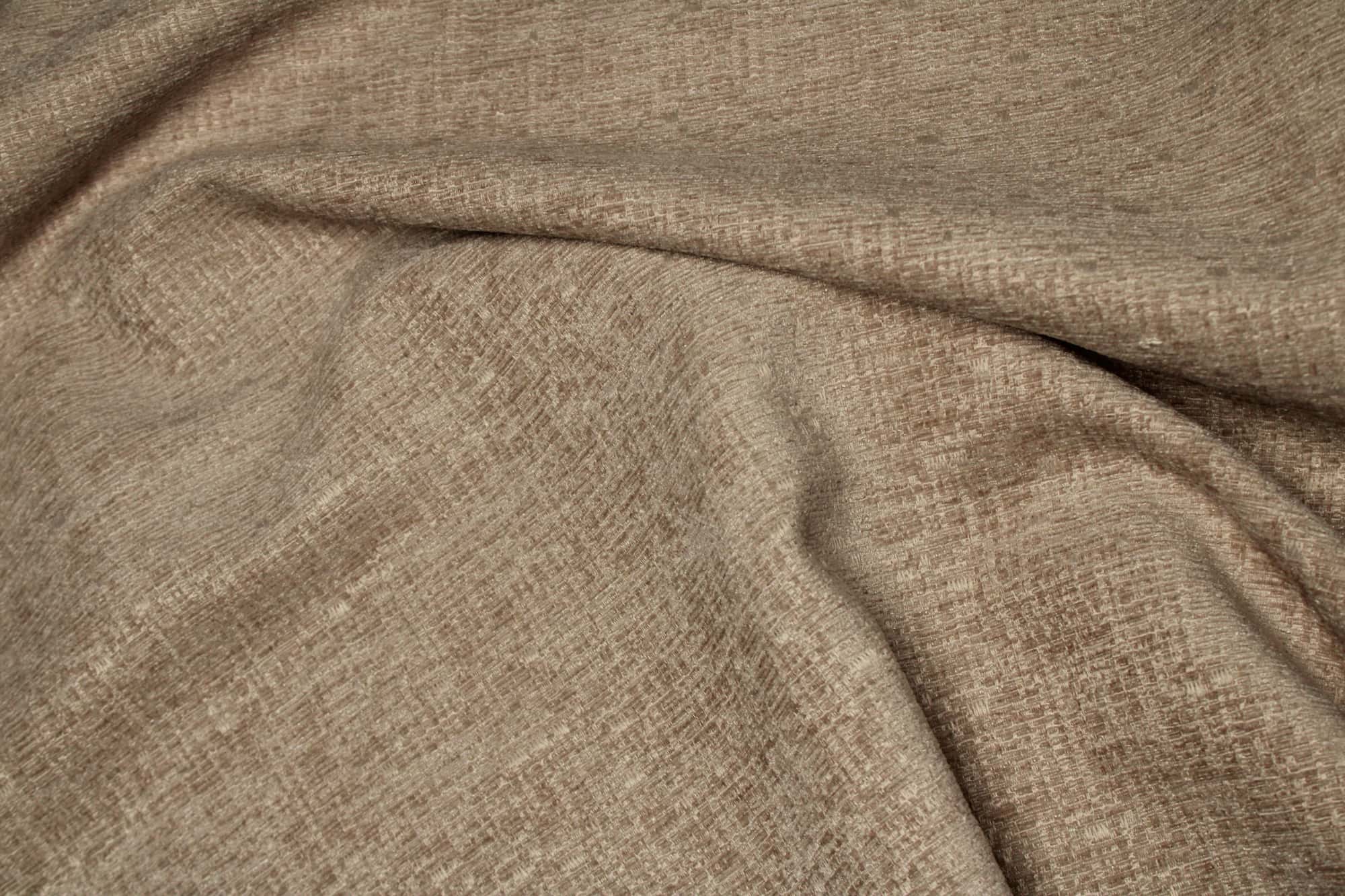 Stofstructuur van zandkleurige teddy chenille gordijnen van Okika, van dichtbij gefotografeerd met stof inelkaar gedraaid