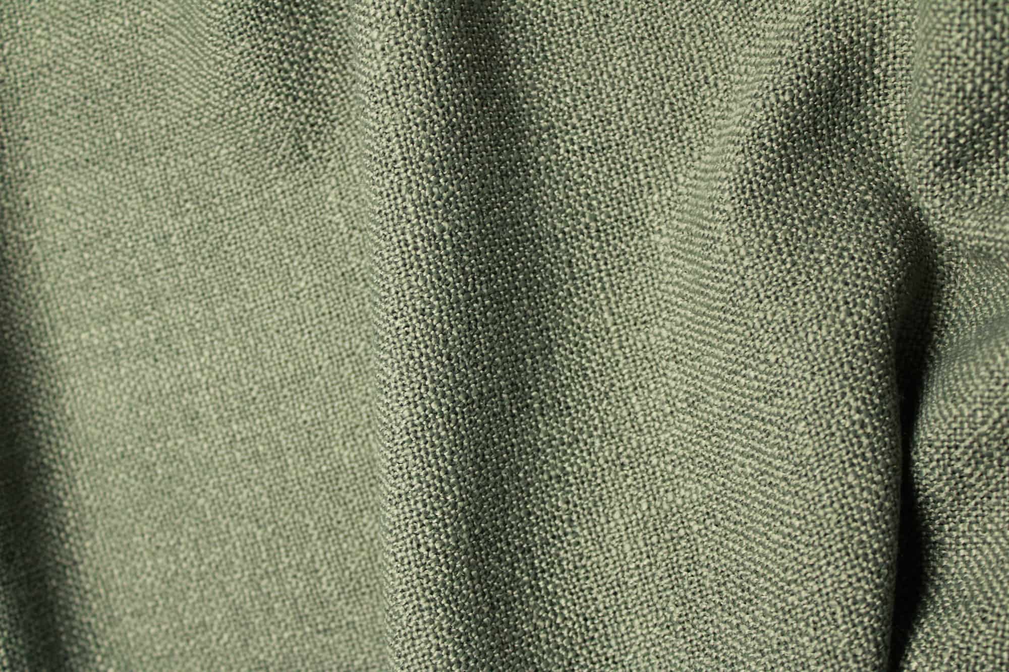 Stofstructuur van zeegroene semilichtdoorlatende gordijnen uit de Boucloir collectie JC2610 met duidelijk zichtbaar overtwijst garen en een grove weving.