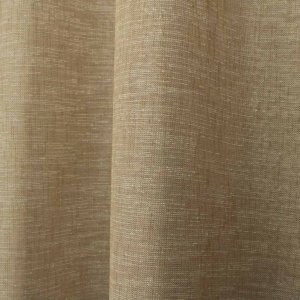 Sfeerfoto van beige linnenlook gordijnen in een warm en rustig interieur. De gordijnen zijn in plooien opgehangen en zorgen voor een zachte lichtinval.