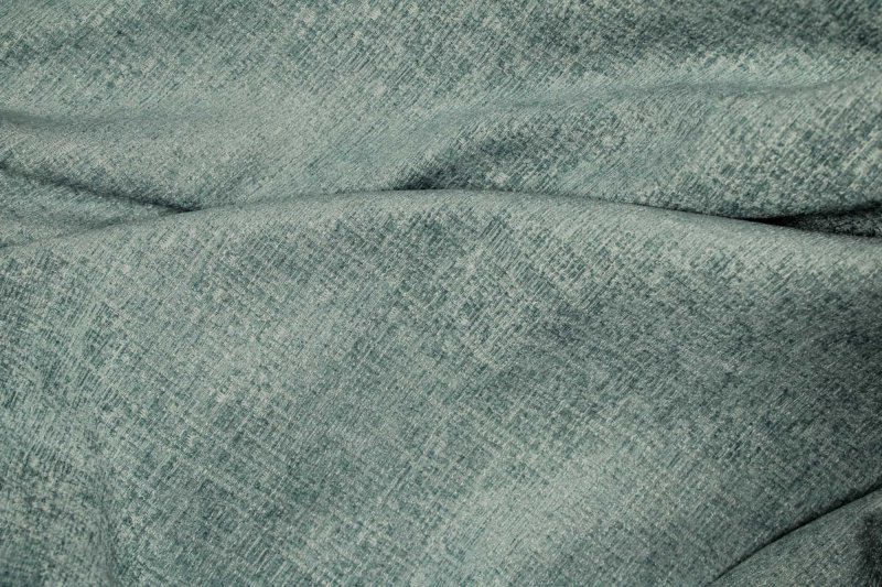 Blauwe vouwgordijnen uit de teddy chenille collectie, als sfeerfoto met de stof in vouwen en een rustige, comfortabele uitstraling