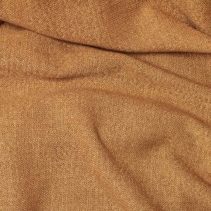 Sfeerfoto van cognac vouwgordijnen uit de Boucloir collectie, met een bouclé achtige stof en duidelijke structuur