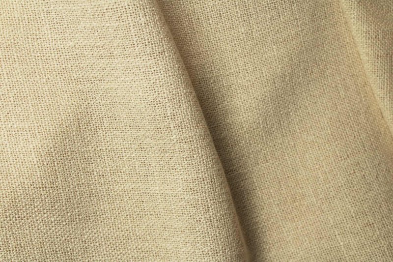 Sfeerfoto van crème vouwgordijnen uit de Boucloir collectie, met een bouclé achtige overtwist garen met grove structuur