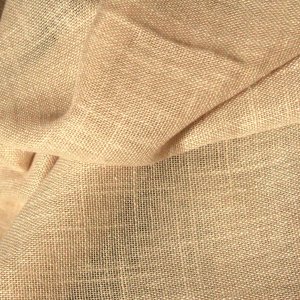 Sfeerfoto van ivoorkleurige vouwgordijnen uit de Saphira Light collectie, de stof gevouwen in een rustige interieursetting met zachte lichtinval.