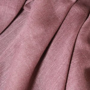 Sfeervolle foto van paarse vouwgordijnen uit de Saphira Light collectie in plooien, getoond in een interieur-setting met zachte daglichtinval.