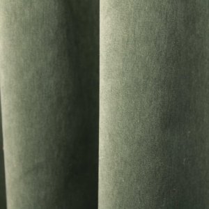 De groengrijze velours SYM2681 uit de Noble collectie, sfeerfoto waarbij de stof hangt in plooien