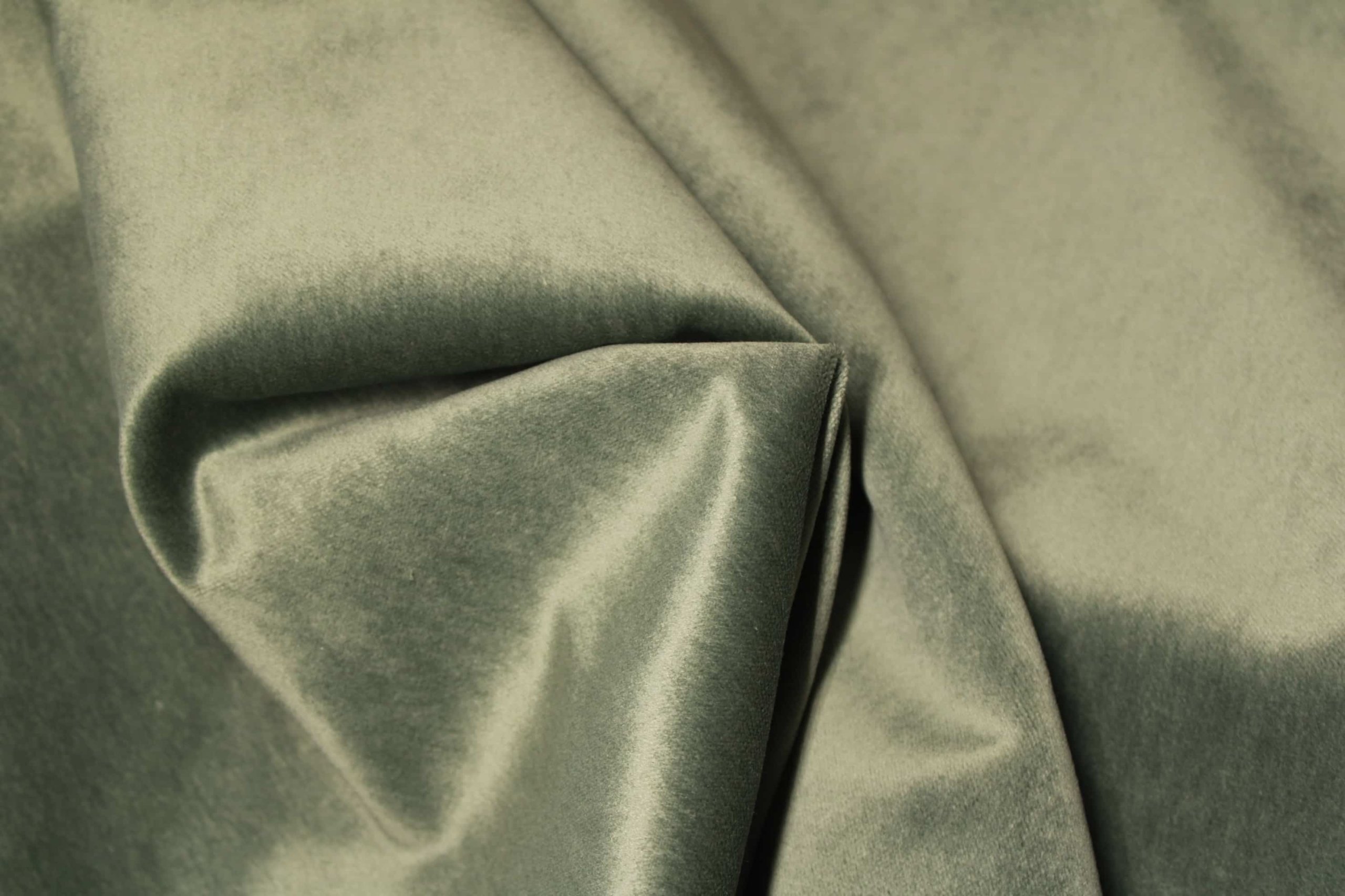 De stofstructuur van de groengrijze velours Noble collectie SYM2681 toont een dichte, fluweelzachte stof