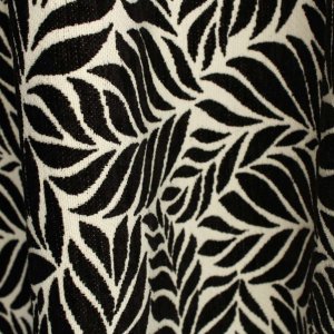 Close-up van jacquard chenille gordijnen in zwart met ingeweven bladmotief, details van de stof goed zichtbaar