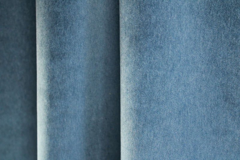 Sfeer foto waarop de kobaltblauwe velours gordijnen uit de Noble collectie SYM2683 stijlvol in plooi hangen.