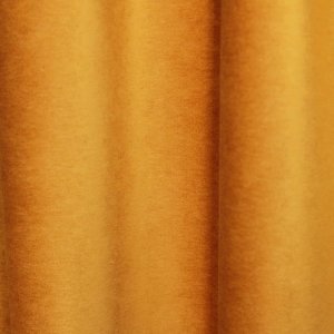 Sfeer foto waarop de okergele velours gordijnen uit de Noble collectie SYM2679 stijlvol in plooi hangen.