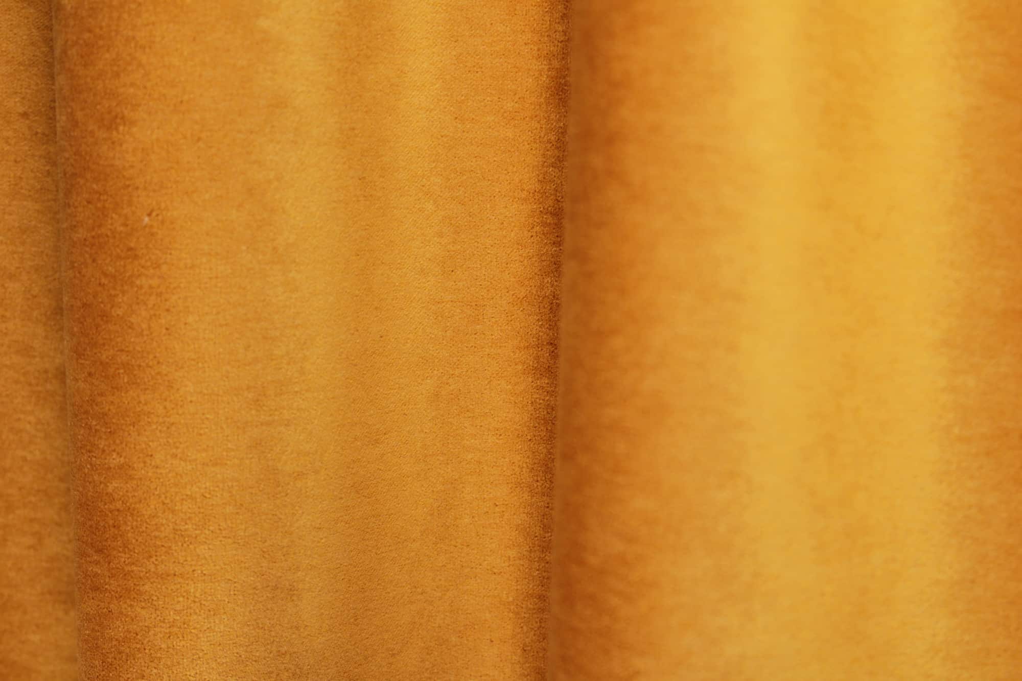 fstructuur van okergele velours gordijnen SYM2679 met nadruk op de volle, egale vezelstructuur.