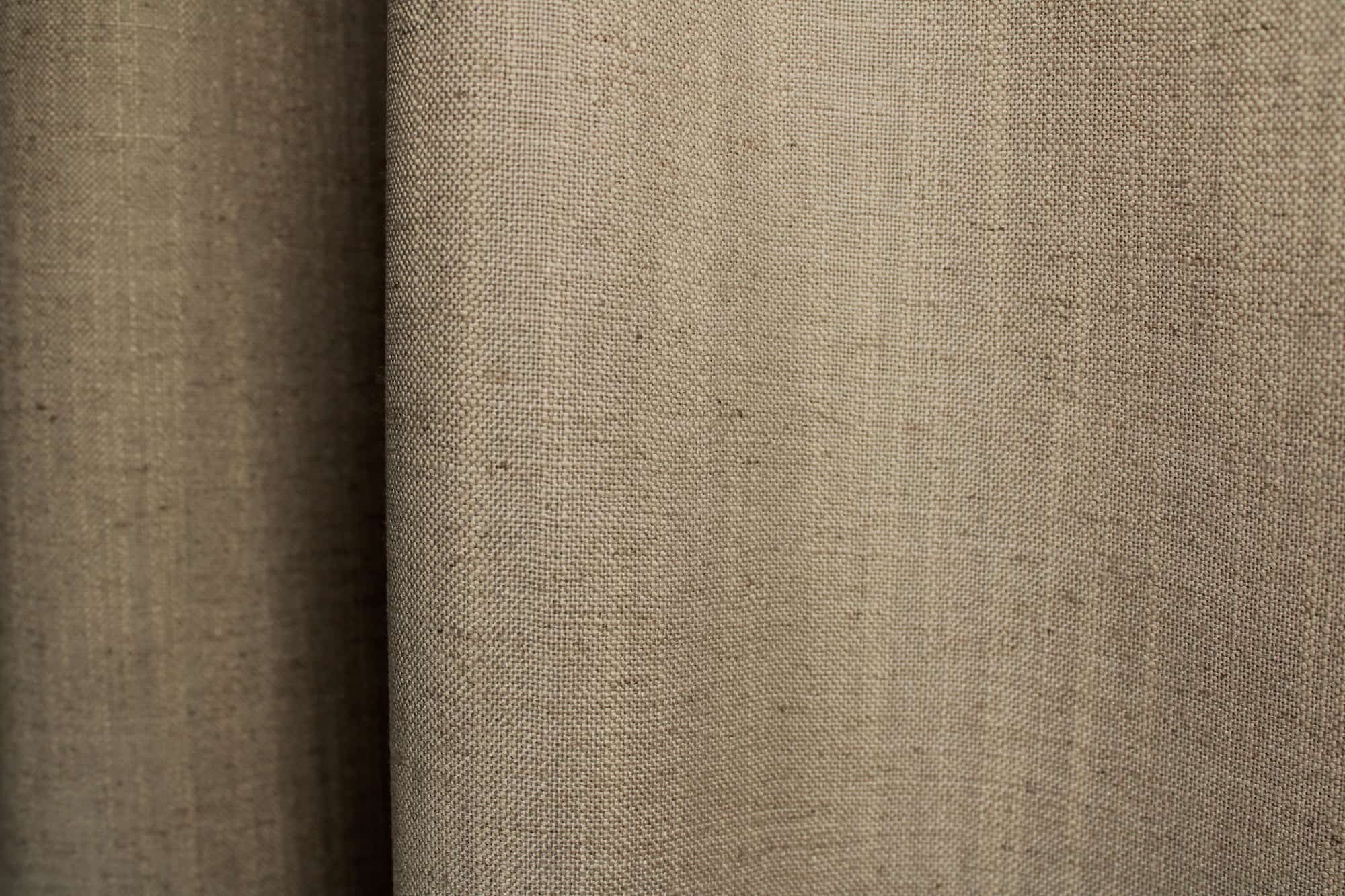 close up van taupe gordijnen met linnenlook structuur