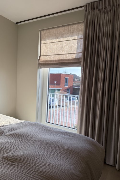 elegance-softtaupe-combinatie-vouwvgordijn-overgordijn-sfeerfoto-slaapkamerklant foto van een slaapkamer met okika vouwgordijnen gecombineert met overgordijne, de elegance soft taupe