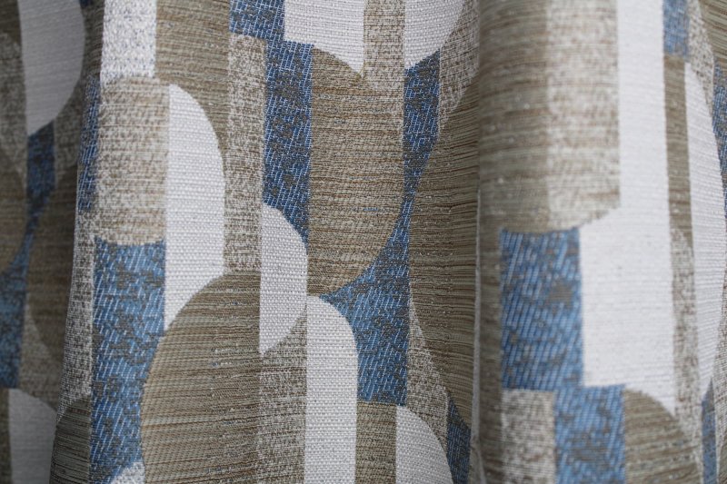 Blauwe gordijnen met vintage grafisch dessin sfeerfoto in plooien