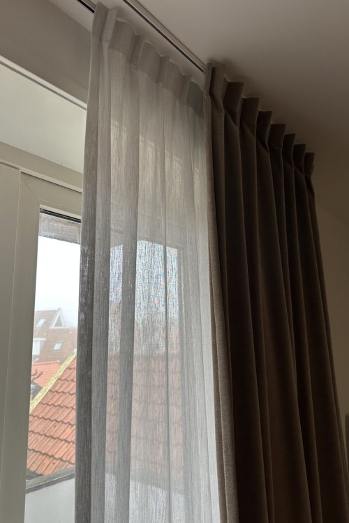 cominatie van overgordijn en inbetween gordijn uitgevoerd in een enkeleplooi, foto van een klant waar gordijnen half open zijn