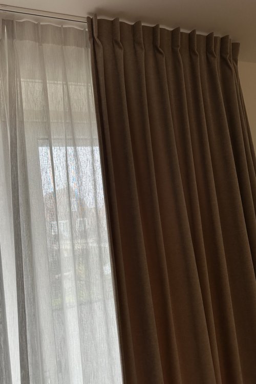 cominatie van overgordijn en inbetween gordijn uitgevoerd in een enkeleplooi, foto van een klant waar foto gemaakt isvan de afwerking dichbij