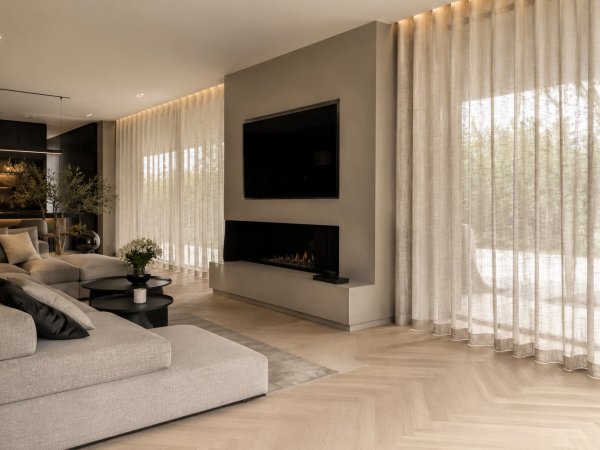 lichte-eiken-visgraatvloer-sfeerimpressie-beige-gordijnen Sfeerfoto ter inspiratie van beige gordijnen in plooi gecombineerd met een lichte eiken visgraatvloer in een modern interieur.