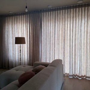 linnen look gordijnen uit de elegance collectie in dubbele plooi met subtiele structuur en zachte lichtinval in een modern interieur van een klant de kleur soft taupe