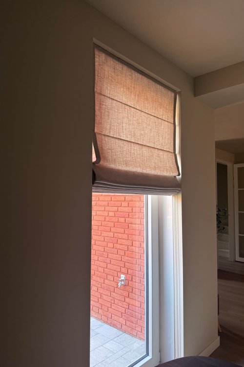 linnen look vouwgordijnen met baleinen aan de achterzijde volledig opgetrokken in een moderne woonkamer
