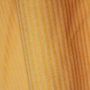 Close detail van gele gordijnstof met gestreept visgraatdessin
