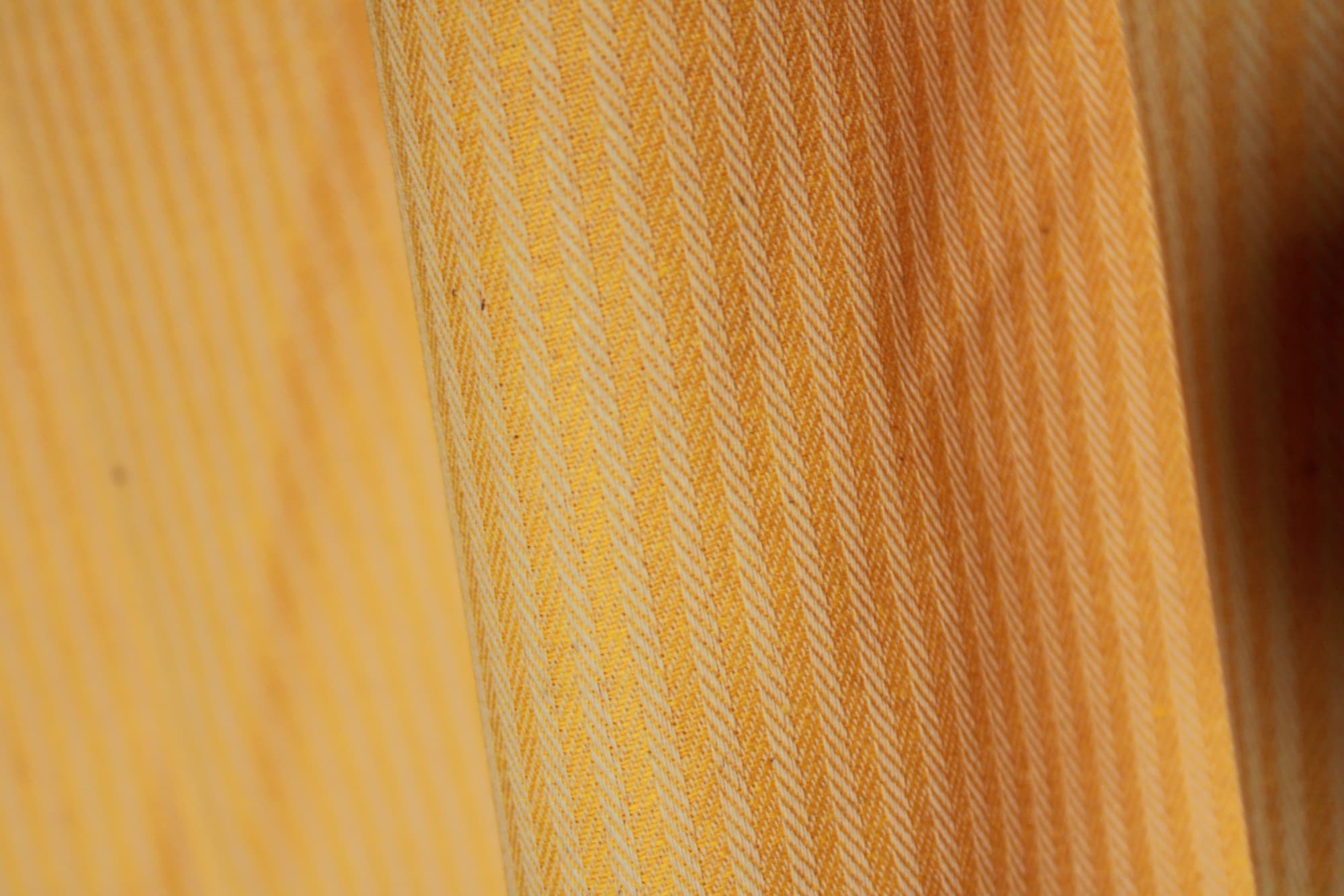 Close detail van gele gordijnstof met gestreept visgraatdessin