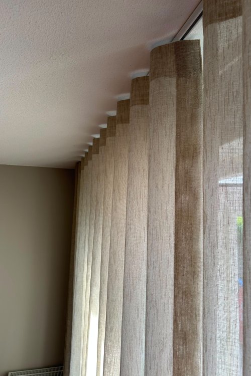 beige inbetween gordijnen in een wave plooi van 8cm, interieur foto van een klant in een woonkamer, close up van de beige inbetween linnenlook gordijnen