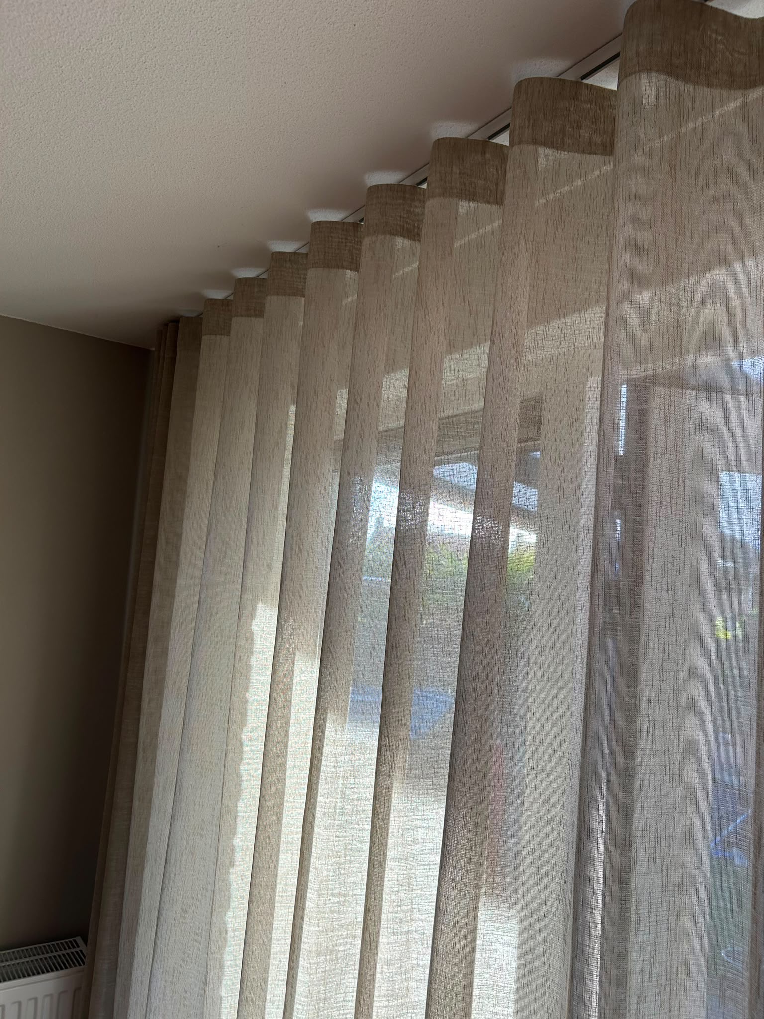 beige inbetween gordijnen in een wave plooi van 8cm, interieur foto van een klant in een woonkamer, details van de wave gordijnen met linnen look