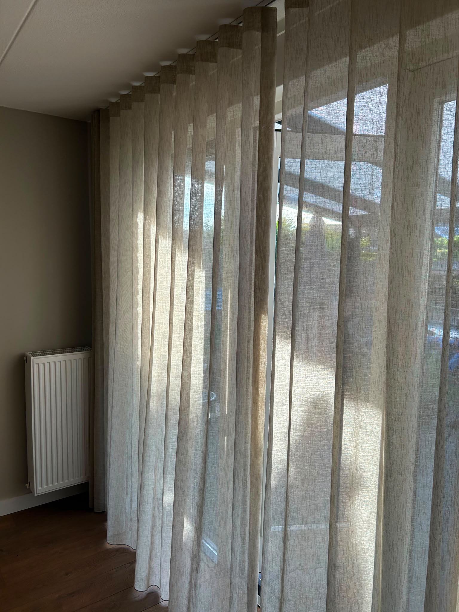 beige inbetween gordijnen in een wave plooi van 8cm, interieur foto van een klant in een woonkamer,
