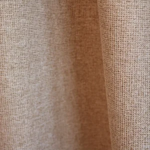 Stofdetail van beige Pureshade verduisterende gordijnen met zicht op de voorzijde en de stof heeft een meekleurende verduisterende achterkant.
