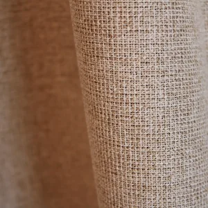 Detail van het stofpatroon van beige verduisterende PureShade gordijnen. De geweven voorzijde geeft de stof een rustige uitstraling.